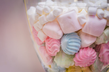 marshmallow, meringue of different colors in a transparent vase