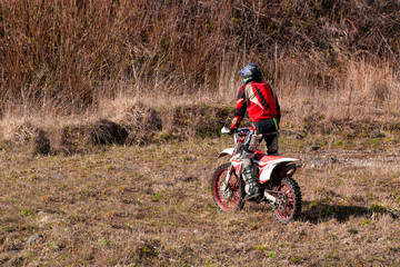 athlete rides a motorcycle on rough terrain.