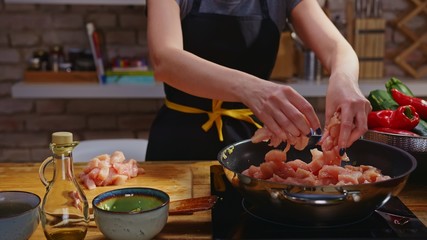 Woman cooking frying in kitchen in wok pan