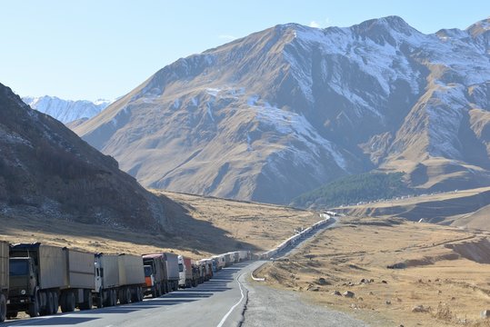Trucks On Road Leading Towards Mountain During Winter
