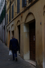 Fototapeta na wymiar Old man walking in the street of Florence
