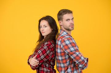 Adult siblings. Sister and brother. Confident team. Back to back standing man and woman. Fashion clothes shop. Modern couple. Couple checkered shirts. Family look. People concept. Family relations