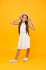 happy childhood of positive girl. beauty. kid summer fashion. ready for beach party. holiday mood. small girl on vacation. rancho child in straw hat. little cutie on yellow backdrop. Getting gold tan