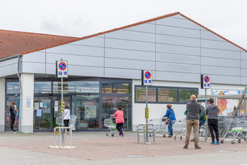 People with protective masks queuing outside a supermarket due to the Covid-19 coronavirus which obliges customers to quota admissions