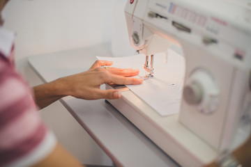 Mãos costurando na máquina