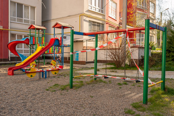 Fototapeta na wymiar Playground wrapped in striped red white tape, stay home. Quarantine area for sports, prevention of infection with the covid-19 coronavirus influenza virus
