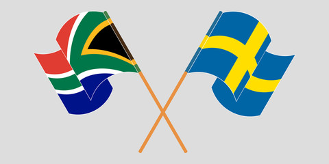 Crossed and waving flags of South Africa and Sweden