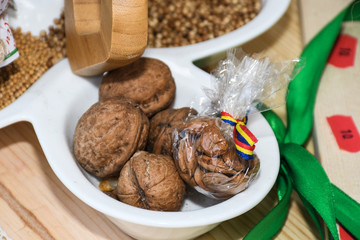 Tasty walnuts in bowl, closeup pile next to mustard seeds