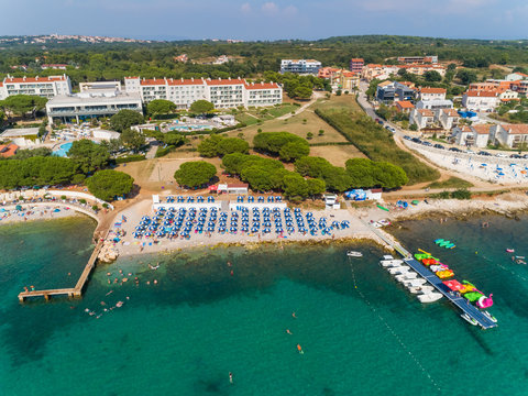 Aerial view of blue umbrellas at Medulin beach during the summer, Croatia.