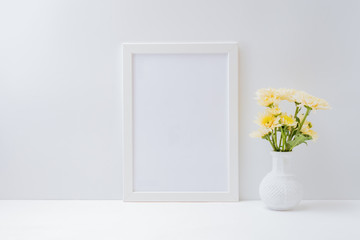 Home interior with decor elements. Mockup with a white frame and flowers in a vase on a light background