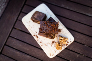 Cremoso brownie con nueces y cacao en polvo. Fondo rústico y oscuro. Vista desde arriba.