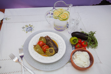 Eggplants are stuffed with meat lamb and rice. Patlican . eggplant filling . Eggplant, peppers, tomatoes . Yogurt in a brown bowl . Chopped lemon in a glass jar . Stuffed eggplant in the plate .