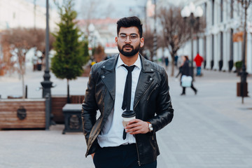 Bearded stylish indian man outdoors takes away coffee