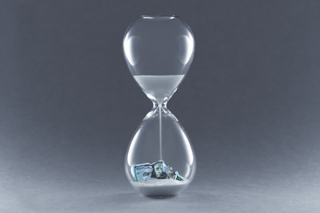 Hourglass on dark background. Concept passing traditional currency time. End of dollar currency.
