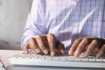 young man typing on keyboard in office