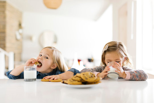 Girls eating milk and cookies