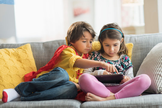 Children (6-7) playing game on tablet pc at home