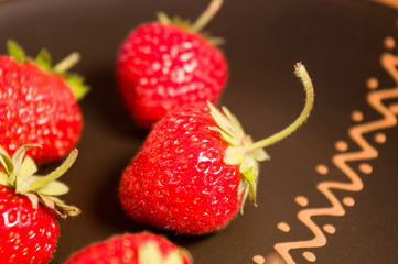 fresh ripe berries strawberries on black ceramic plate, close up