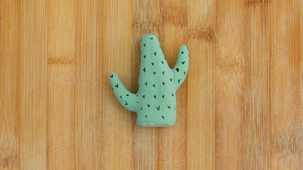 figura en forma de cactus encima de una tabla  de madera