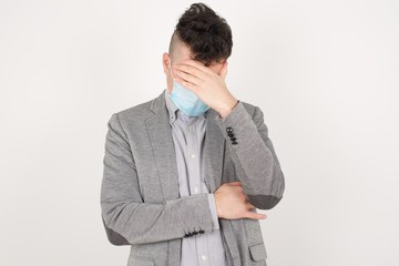 Indoor portrait of handsome man with stylish haircut, wearing casual clothes, making facepalm...