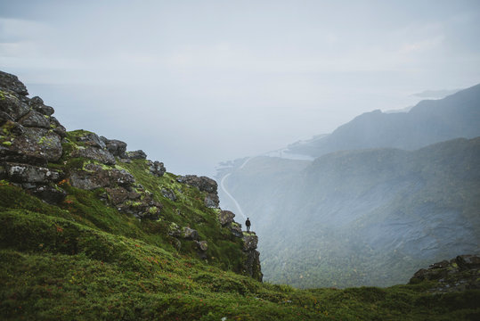 Norway, Lofoten Islands, Reine, Man looking at view from&dagger;Reinebringen&dagger;mountain during rain