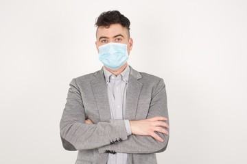 Waist up portrait of young handsome caucasian male with positive expression, has crossed arms, feels happy and confident, wears casual clothes, isolated over gray background.