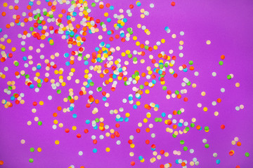 Purple background with vivid confetti. Colorful abstract backdrop with scattered paper circles. Beautiful decor for the party. Festive composition for celebration. View from above. Flat lay