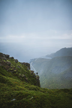 Norway, Lofoten Islands, Reine, Man looking at view from&dagger;Reinebringen&dagger;mountain during rain