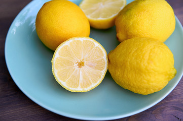 Beautiful ripe lemons on a plate. Vitamin C in fruits.