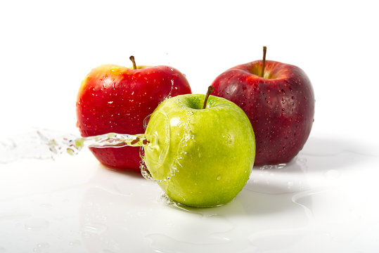 three apples with water splash. Three apples red, green, and yellow with warer splashes on white background