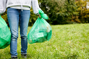 Woman stuffing soft waste plastics into large plastic bottle to make an ecobrick for use as a building block