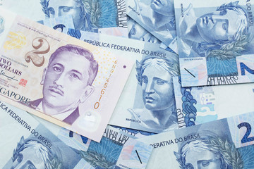 Fototapeta premium A close up image of a two dollar bill from Singapore close up in macro with Brazilian two reais bank notes
