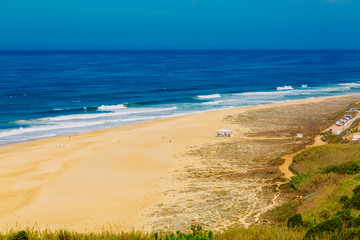 View of sandy North beach and blue Atlantc Ocean in Nazare, Portugal