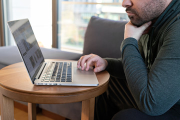 man working online at home or study using laptop on sofa. Stay home quarantine