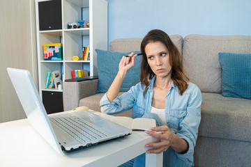 Busy Serious Woman working at home on a laptop computer