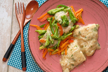 Baked fish fillet with fresh salad top view.