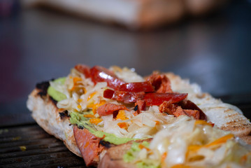 Fast food prepared on the street in Guatemala, Central America, bread with sausages, cabbage, avocado and sauces, called Shuco Chapina version of hot dog, danger of contagion of diseases and Covid 19.