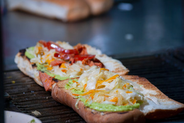 Fast food prepared on the street in Guatemala, Central America, bread with sausages, cabbage, avocado and sauces, called Shuco Chapina version of hot dog, danger of contagion of diseases and Covid 19.