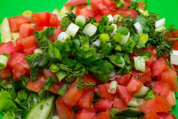 Sliced cucumbers, tomatoes, onions. Ingredients for the salad. Blurred background