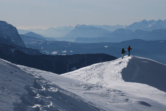 Couple hiking on sunny, scenic snowy mountain, Brixen, South Tyrol, Italy