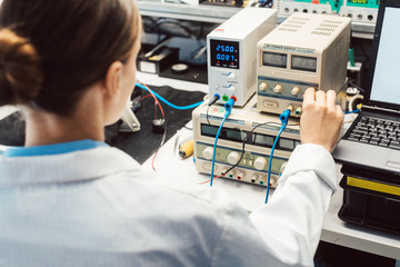 Engineer woman in electronics lab testing EMC compliance