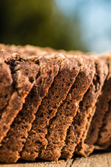 Fresh rye bread or whole grain bread on dark table background. Healthy baked bread in slices, whole homemade bread. Organic food. 
