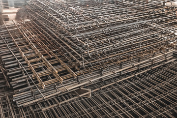 Reinforcement of concrete structures. Armature with traces of rust on the background of an industrial workshop. Fitting