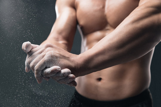 Bodybuilders hand in daub slippery powder