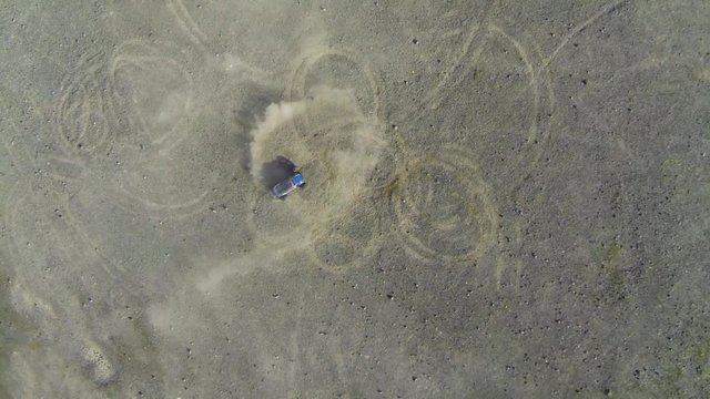 Voiture qui drift dans les graviers film&eacute; par un drone vu du ciel