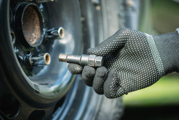 Tire worker removes wheel from a car close up.