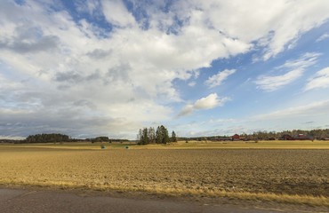 Beautiful nature landscape view on spring day. Plowed field merging with blue sky and white clouds....