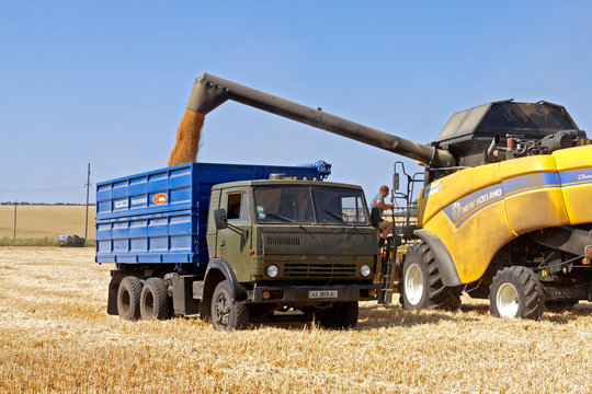Kharkiv Region, Ukraine - July 25, 2017: Combine harvester load wheat in the truck at the time of harvest in a sunny summer day in Kharkiv Region, Ukraine on July 25, 2017.