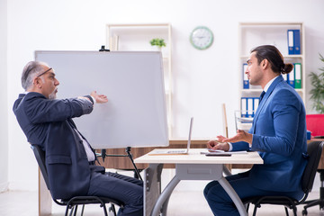 Yound and old employees in business presentation concept