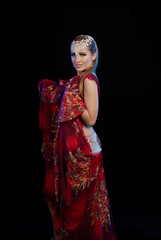 Fototapeta na wymiar Young woman belly dancer in a red oriental costume on a black background